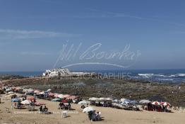 Image du Maroc Professionnelle de  Pour se désennuyer certains casablancais vont au bord de la mer, de la baie de la mosquée (Mriziga) jusqu’à l’îlot du rocher de sidi Abderrahmane environ sur 8 km de corniche. Une ambiance particulièrement locale très appréciée quelques visiteurs profitent du lieu sous les parasols pour manger des crêpes marocaines (Msamen) ou des galettes (Al Harcha) accompagné d'un thé à la menthe, avant de se donner aux joies de découverte avec leur petit de la vie marine sur les rocher qui entourent l’îlot. Les pèlerins accèdent au site pour se purifier, jeter un sort ou faire un sacrifice. Dimanche 7 Octobre 2012. (Photo / Abdeljalil Bounhar) 